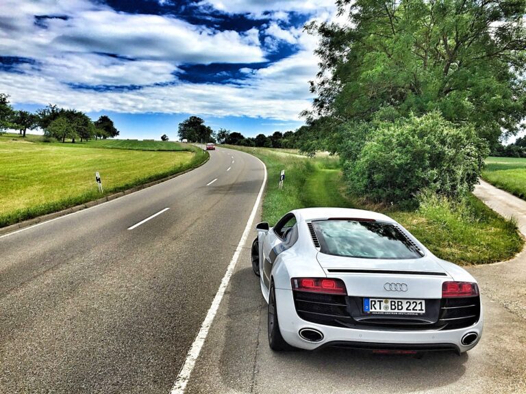 Qué beneficios ofrece la libreta internacional del Automóvil Club 24 automovil en carretera con paisaje de fondo