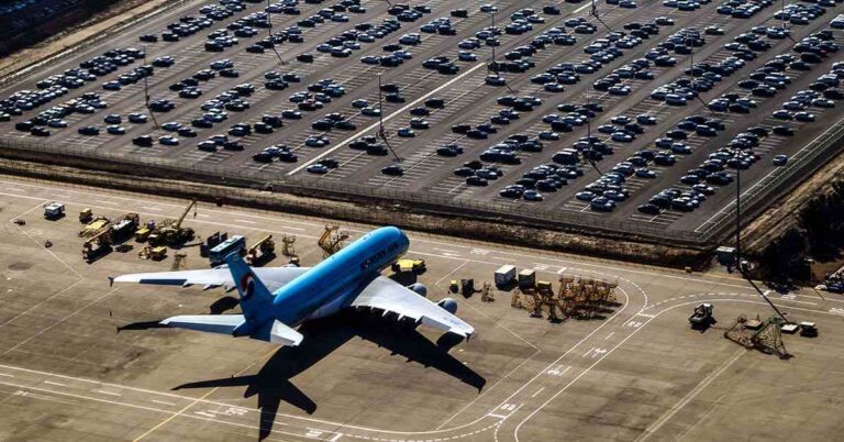 estacionamiento en aeropuerto con coches y aviones
