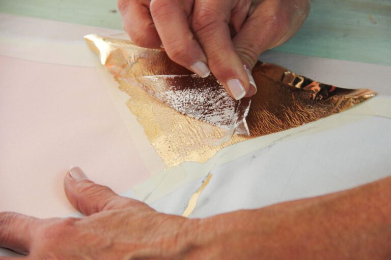 manos aplicando pegamento sobre superficie dorada