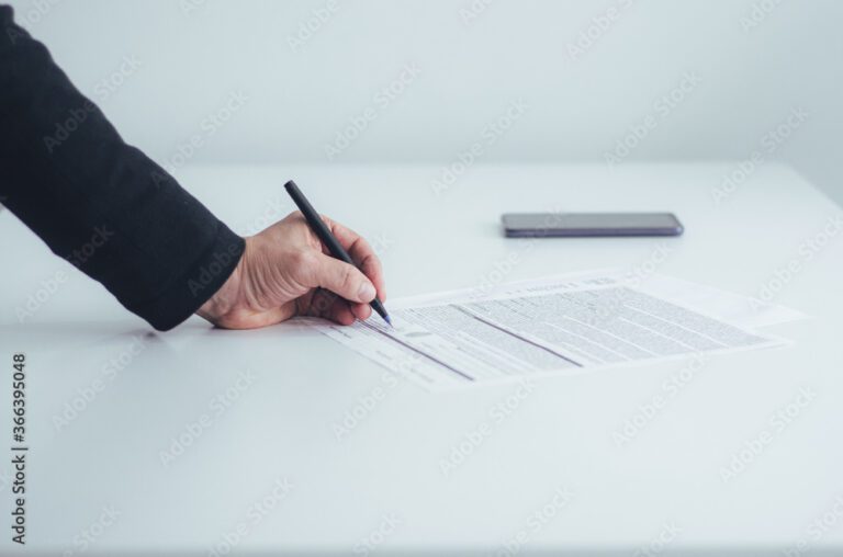 manos firmando un contrato en una mesa