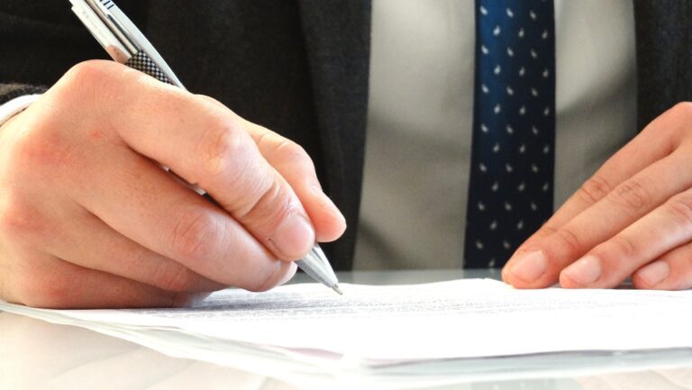 manos firmando un documento legal 2