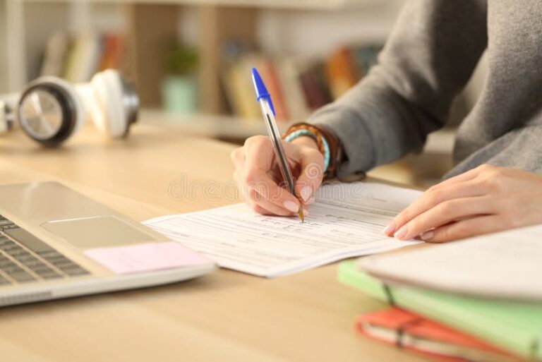 manos llenando un formulario en escritorio