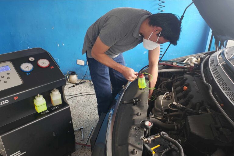 mecanico revisando un aire acondicionado automotriz
