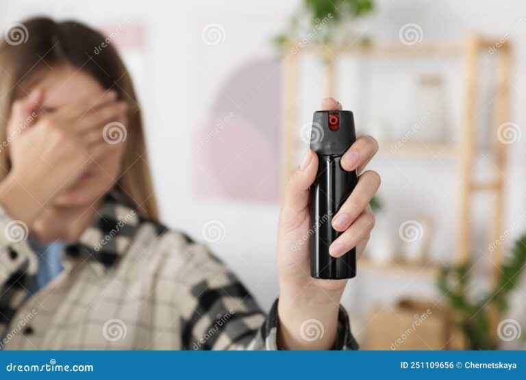 mujer sosteniendo gas pimienta en mano