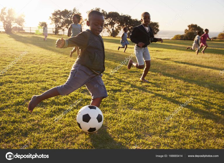 ninos jugando futbol en un campo