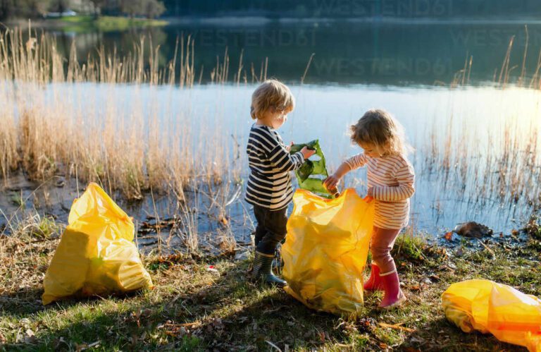 ninos recogiendo basura en la naturaleza