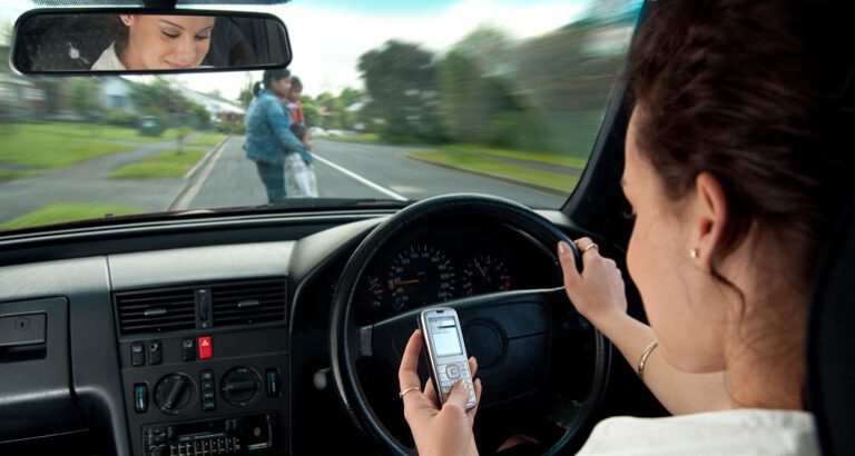 persona usando celular mientras conduce