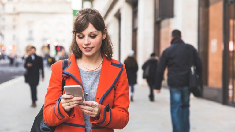 Cómo puedo contactar a Uber en Chile para resolver mis dudas 19 persona usando un smartphone en la calle